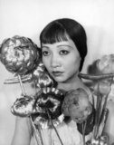 Anna May Wong (January 3, 1905 – February 3, 1961) was an American actress, the first Chinese American movie star, and the first Asian American to become an international star. Her long and varied career spanned both silent and sound film, television, stage, and radio.<br/><br/>

Born near the Chinatown neighborhood of Los Angeles to second-generation Chinese-American parents, Wong became infatuated with the movies and began acting in films at an early age. During the silent film era, she acted in The Toll of the Sea (1922), one of the first movies made in color and Douglas Fairbanks' The Thief of Bagdad (1924). Wong became a fashion icon, and by 1924 had achieved international stardom. Frustrated by the stereotypical supporting roles she reluctantly played in Hollywood, she left for Europe in the late 1920s, where she starred in several notable plays and films, among them Piccadilly (1929). She spent the first half of the 1930s traveling between the United States and Europe for film and stage work.<br/><br/>


Wong was featured in films of the early sound era, such as Daughter of the Dragon (1931) and Daughter of Shanghai (1937), and with Marlene Dietrich in Josef von Sternberg's Shanghai Express (1932). In 1935 Wong was dealt the most severe disappointment of her career, when Metro-Goldwyn-Mayer refused to consider her for the leading role in its film version of Pearl S. Buck's The Good Earth, choosing instead the German actress Luise Rainer to play the leading role. Wong spent the next year touring China, visiting her family's ancestral village and studying Chinese culture.<br/><br/>


In the late 1930s, she starred in several B movies for Paramount Pictures, portraying Chinese-Americans in a positive light. She paid less attention to her film career during World War II, when she devoted her time and money to helping the Chinese cause against Japan. Wong returned to the public eye in the 1950s in several television appearances as well as her own series in 1951, The Gallery of Madame Liu-Tsong, the first U.S. television show starring an Asian-American. She had been planning to return to film in Flower Drum Song when she died in 1961, at the age of 56. 